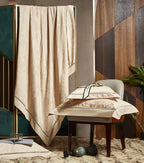 Gold damask bedding draped over an accent chair to display its flowing satin finish and elegant jacquard pattern - L&B