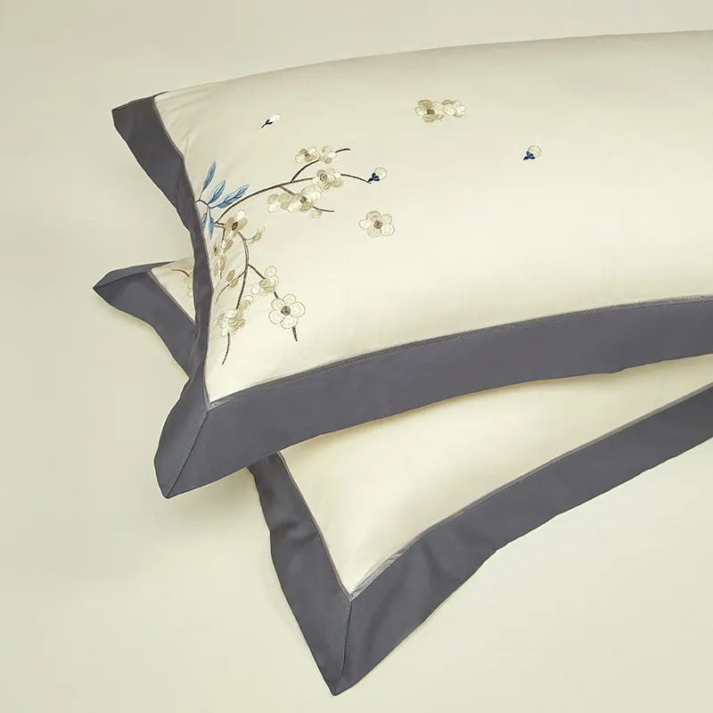 Coordinating ivory pillow shams with gray borders and delicate blue botanical embroidery – L&B