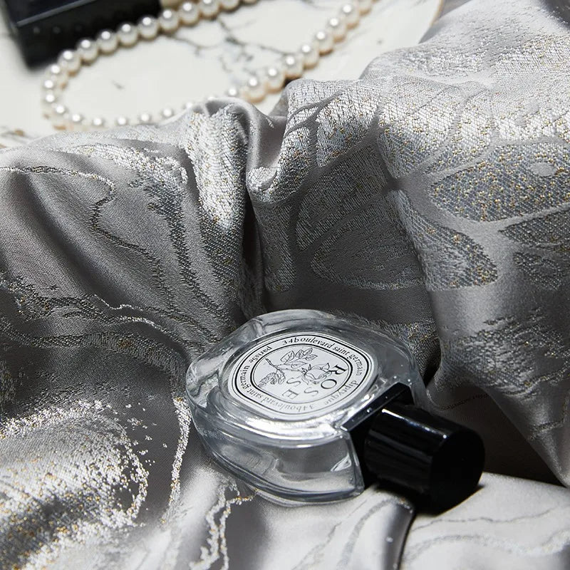 Detailed view of silver jacquard bedding highlighting the intricate dragon and cloud motif and reflective platinum sheen – L&B