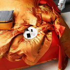 Detailed view of luxury burnt orange bedding showing the soft drape, intricate jacquard pattern, and copper sheen – L&B