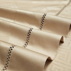 Close-up of champagne gold long-staple cotton bedding with delicate openwork edge trim, LUSTRA GOLD – L&B