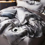 Close-up of charcoal jacquard bedding showing softly gathered folds and reflective platinum threadwork – L&B