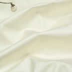 Ivory Egyptian cotton bedding fabric with a smooth finish, soft drape, and gentle natural folds – L&B