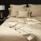 Champagne gold geometric bedding layered with a quilted bedspread and matching pillows, LUSTRA GOLD – L&B