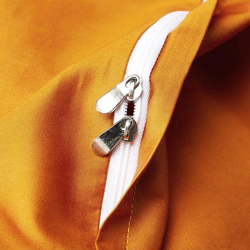 Close-up of the concealed zipper closure on the smooth burnt orange reverse side of the black duvet cover – L&B