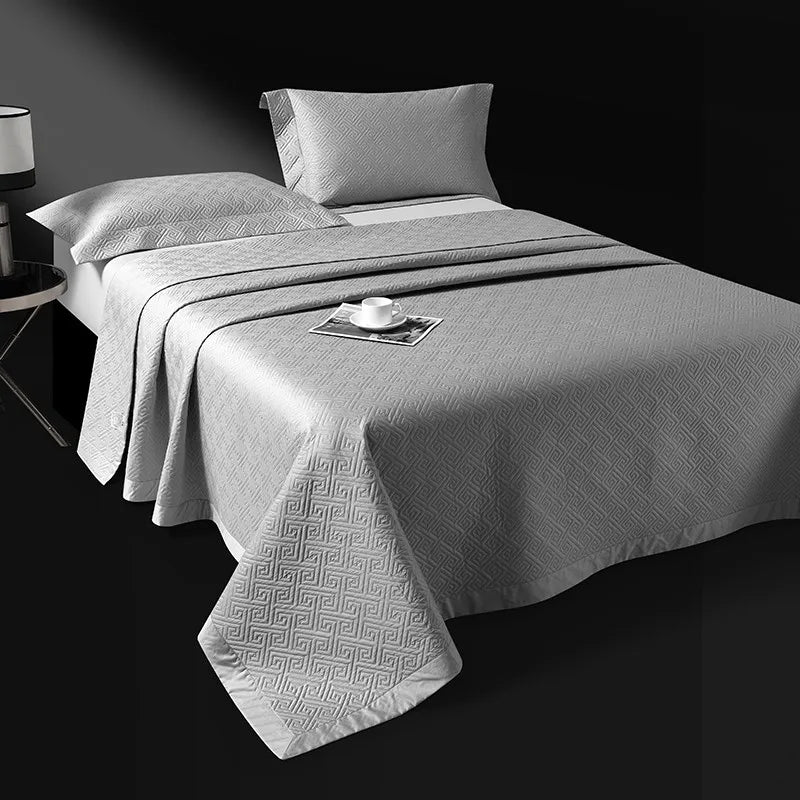 Silver gray quilted bedspread layered over a striped jacquard duvet cover, LUSTRA SILVER – L&B