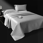Silver gray quilted bedspread layered over a striped jacquard duvet cover, LUSTRA SILVER – L&B