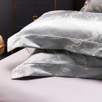 Silver gray jacquard pillow shams stacked to display their lustrous woven pattern and refined tailored edges – L&B