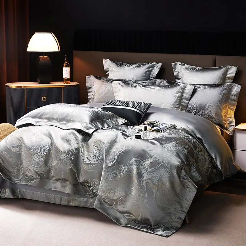 Luxury silver bedding set styled with an intricate jacquard duvet cover, coordinating gray shams, and elegant bedside lighting – L&B