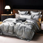 Luxury silver bedding set styled with an intricate jacquard duvet cover, coordinating gray shams, and elegant bedside lighting – L&B
