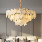 Raw-edge alabaster petal chandelier above a sofa in a warm contemporary living room - L&B