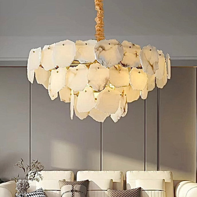 Raw-edge alabaster petal chandelier above a sofa in a warm contemporary living room - L&B
