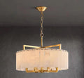 Round alabaster drum chandelier with gold chain suspension and warm ambient lighting