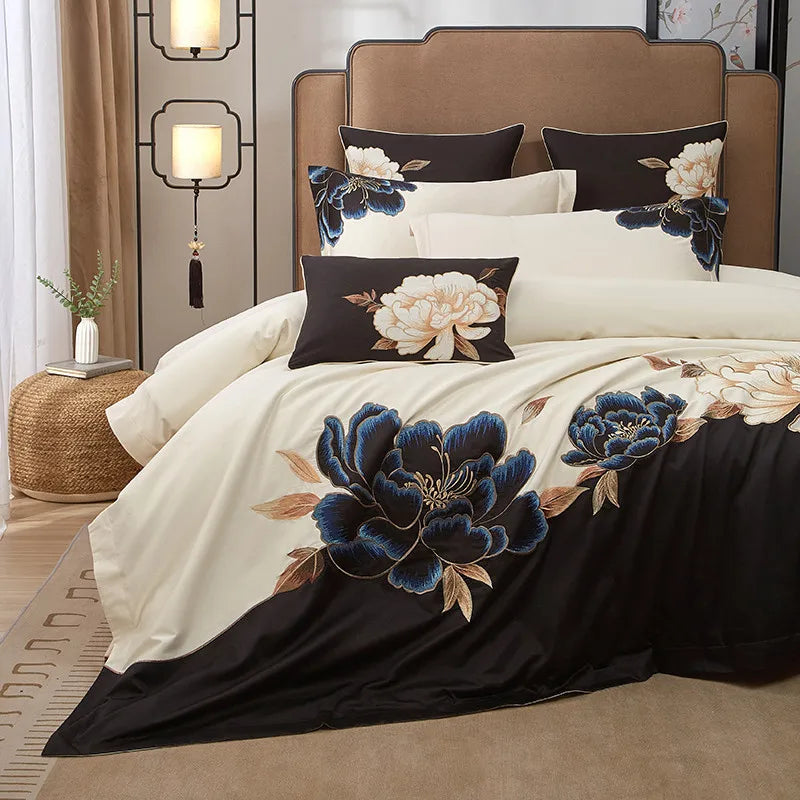 Black floral Egyptian cotton duvet cover set shown from the side with ivory bedding and layered decorative pillows – L&B
