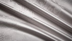 Close-up of smooth silver gray 1200TC Egyptian cotton satin fabric with fluid folds and reflective luster – L&B