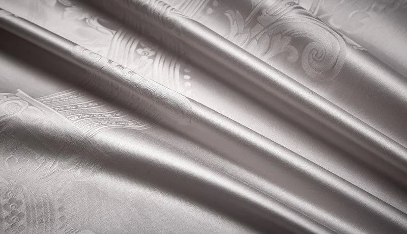 Close-up of smooth silver gray 1200TC Egyptian cotton satin fabric with fluid folds and reflective luster – L&B