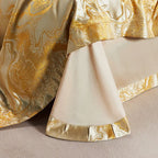 Close-up of a gold marble jacquard duvet cover and white bed sheet finished with a wide patterned gold border – L&B
