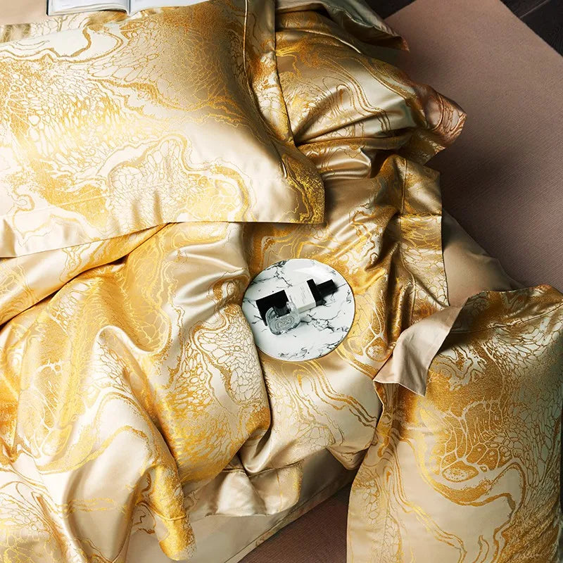Detailed view of a gold satin jacquard duvet cover highlighting its flowing pattern and softly gathered fabric – L&B