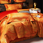 Orange damask duvet cover set with copper-gold jacquard pattern, layered pillows, and contrasting red bedding – L&B