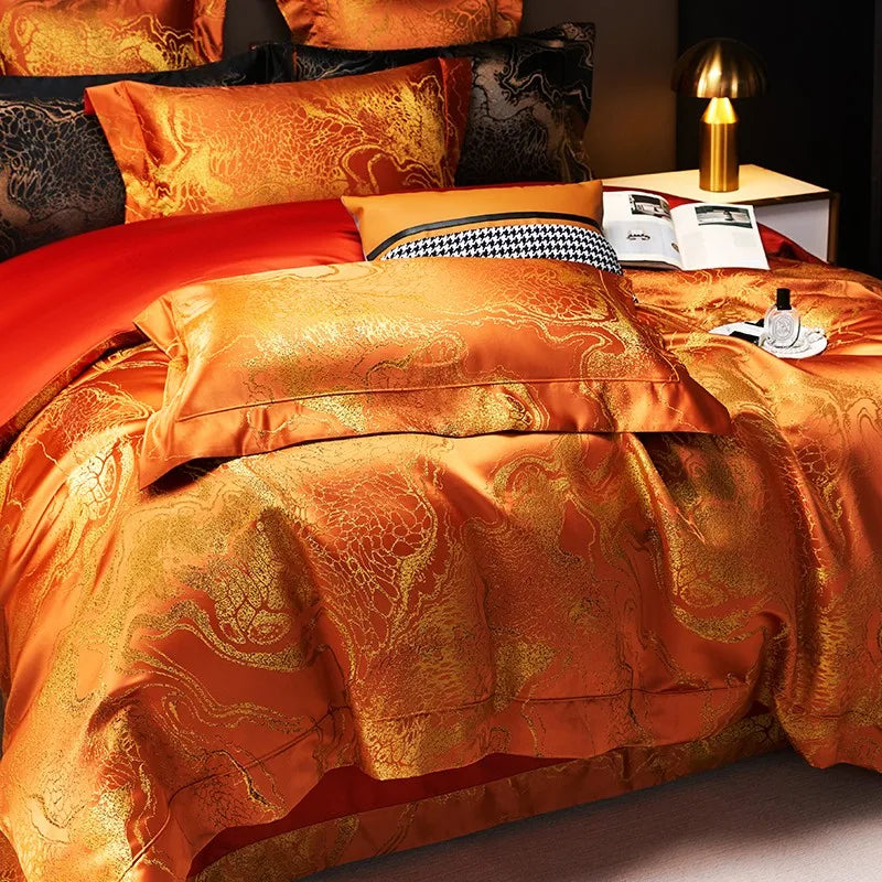 Orange damask duvet cover set with copper-gold jacquard pattern, layered pillows, and contrasting red bedding – L&B
