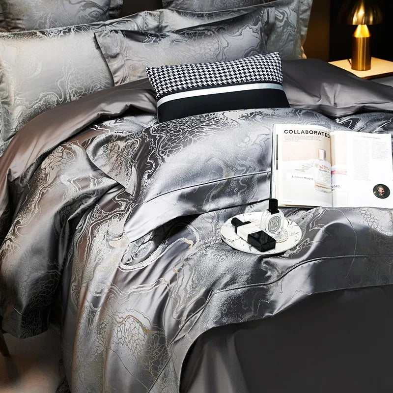 Dark gray luxury bedding set styled with a metallic jacquard duvet cover, layered pillows, and refined bedside details – L&B