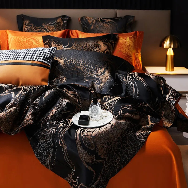 Close-up of a black and gold jacquard duvet cover showing the ornate woven pattern and burnt orange reverse fabric – L&B