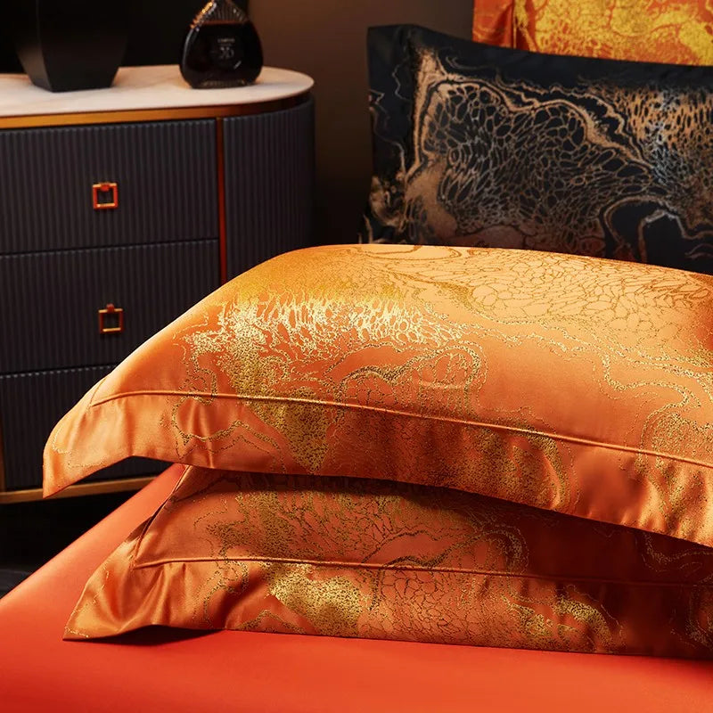 Burnt orange jacquard pillow shams stacked with black damask accent pillows in an elegant bedding arrangement – L&B