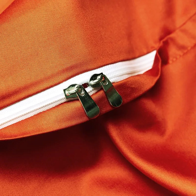 Close-up of the concealed zipper closure on the solid burnt orange reverse side of the duvet cover – L&B