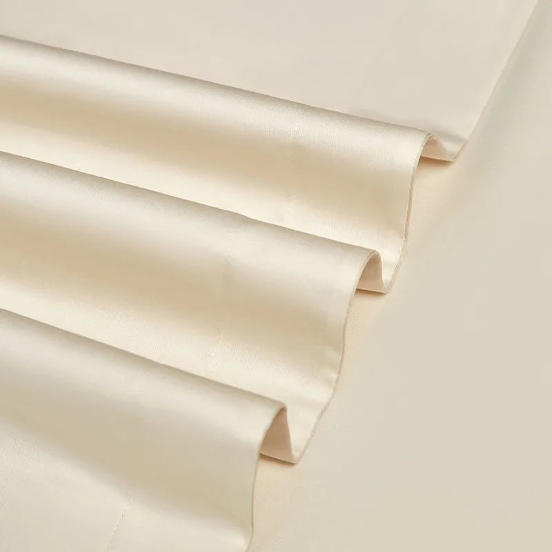 Close-up of layered ivory Egyptian cotton fabric showing its refined weave and softly tailored finish – L&B