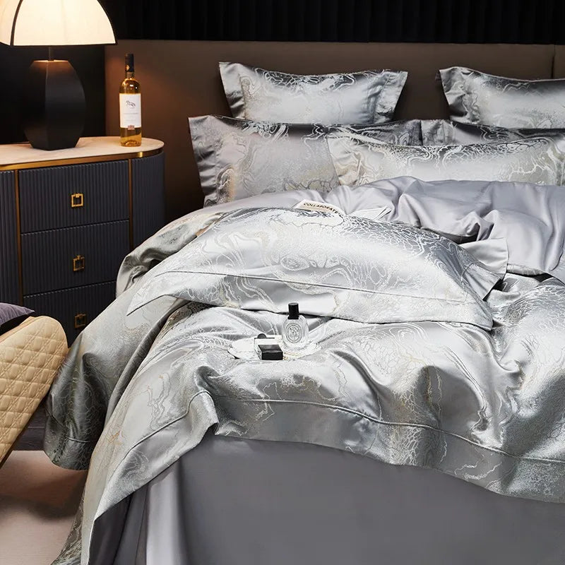 Luxury silver bedding set styled with a jacquard duvet cover, layered gray pillows, and smooth Egyptian cotton sheets – L&B