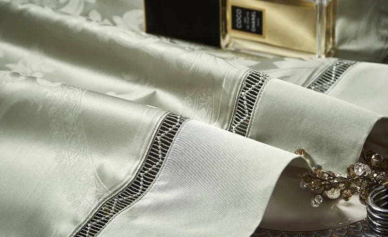 Coordinating sage green pillow shams with damask detailing, braided trim, and a lustrous satin finish – L&B