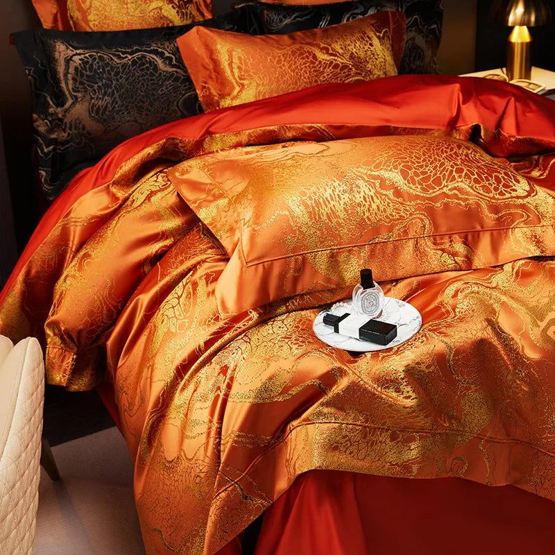 Luxury orange jacquard bedding shown from above with layered pillows, damask detailing, and a rich copper sheen – L&B