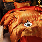 Luxury orange jacquard bedding shown from above with layered pillows, damask detailing, and a rich copper sheen – L&B