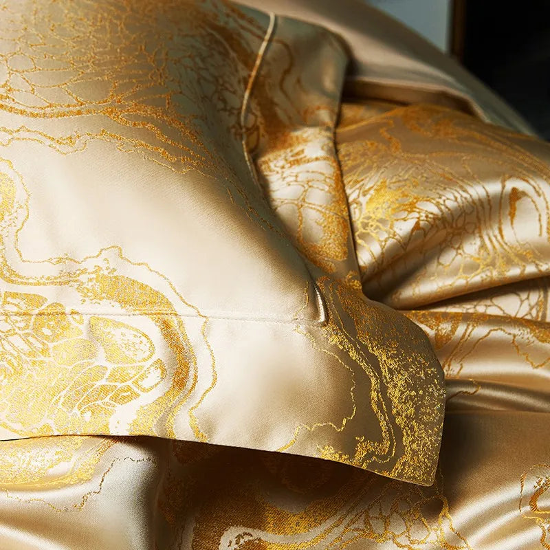 Close-up of champagne gold bedding with a richly folded jacquard duvet and smooth satin reverse fabric – L&B