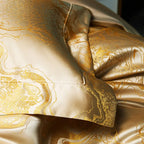 Close-up of champagne gold bedding with a richly folded jacquard duvet and smooth satin reverse fabric – L&B