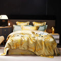 Gold jacquard duvet cover set with a fluid white marble pattern, layered shams, and luminous champagne finish – L&B