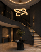 Modern alabaster chandelier in a dramatic foyer with a curved staircase - L&B