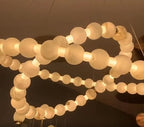Illuminated two-tier alabaster globe ring chandelier with natural stone spheres, brass details, and adjustable suspension – AURELIA