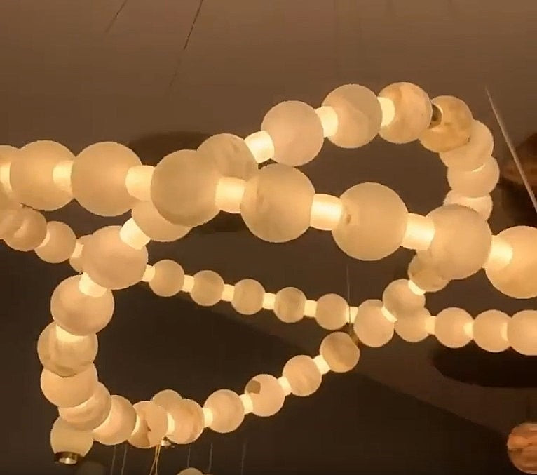 Illuminated two-tier alabaster globe ring chandelier with natural stone spheres, brass details, and adjustable suspension – AURELIA